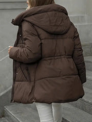 Person wearing a brown puffer coat standing on steps.