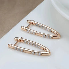 Rose gold earrings with clear gemstones on a white surface