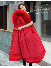 Woman wearing a red winter coat with a fur-lined hood in an urban setting.