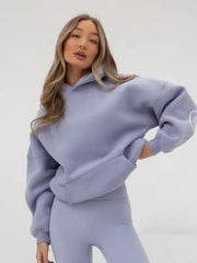 Woman wearing a light blue sweatshirt and pants on a white background