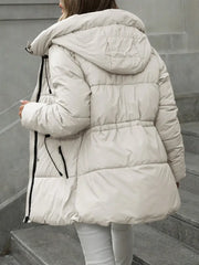 Person wearing a white puffer jacket on a gray staircase