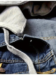 Close-up of a denim jacket with buttons and stitching details.