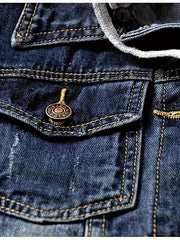 Close-up of a blue denim jacket with a brand logo on the pocket.