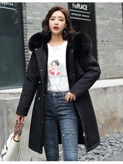 Woman wearing a long black coat with fur hood in an urban setting