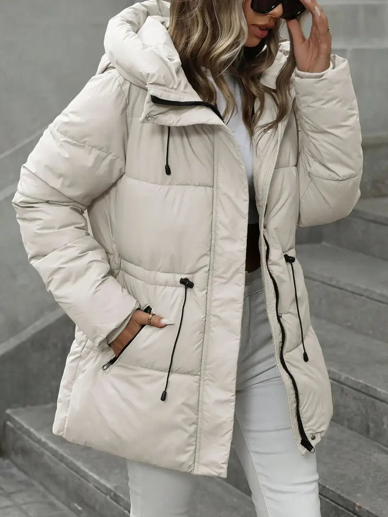 Person wearing a beige puffer jacket on a gray staircase