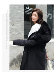 Woman wearing a black coat with fur trim in front of a building.