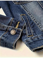 Close-up of blue denim jeans with a button on a light background