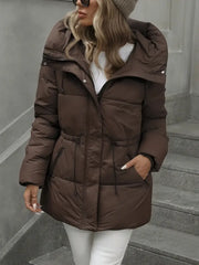 Woman wearing a brown puffer coat on a gray staircase