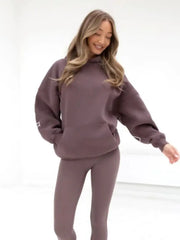 Woman wearing a matching brown hoodie and pants on a white background